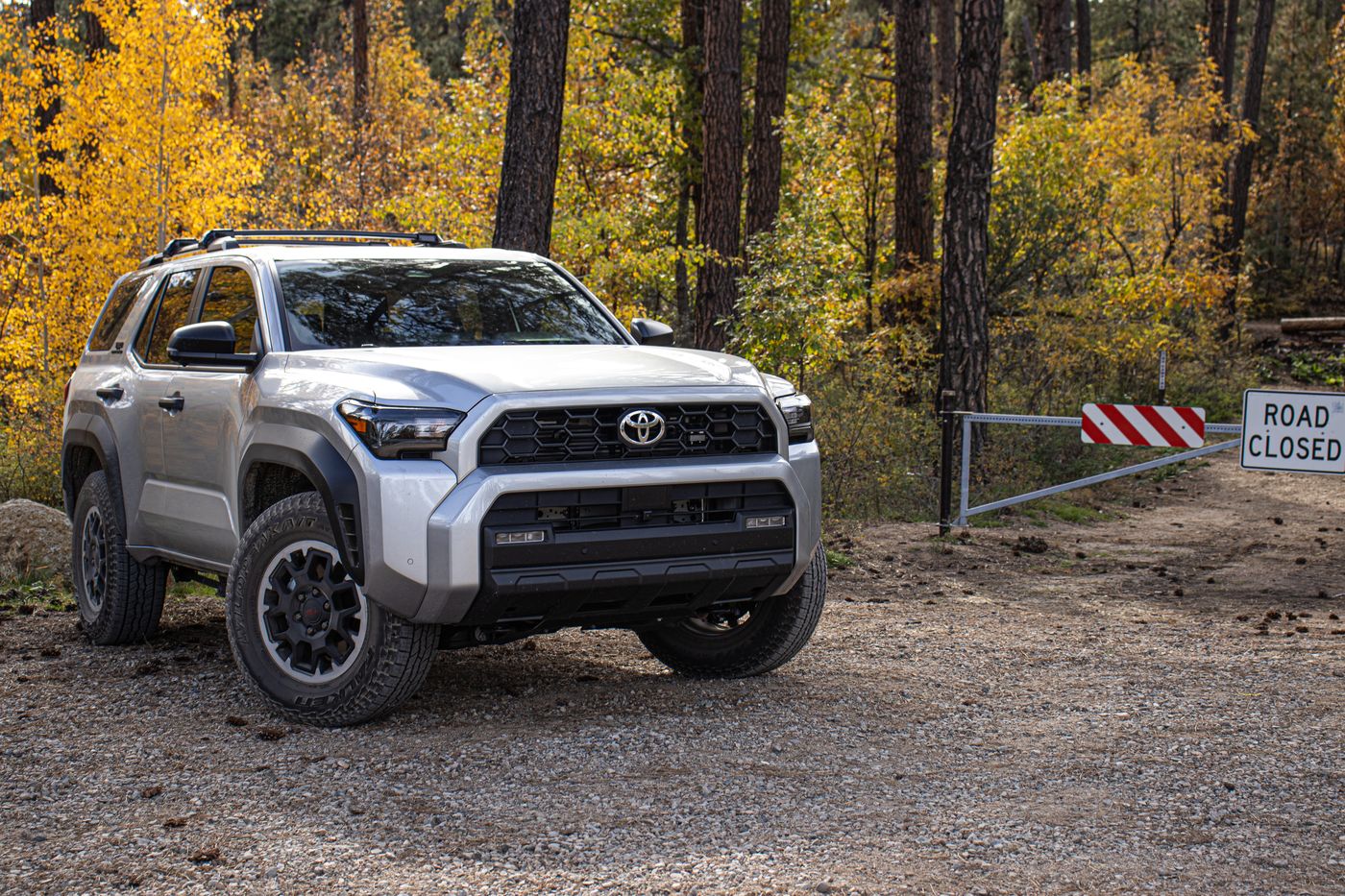 4Runner stopped at a road-closed gate in autumn forest