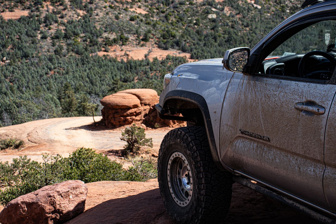 Lifted Toyota Tacoma with awning deployed on a Sedona red-rock overlook