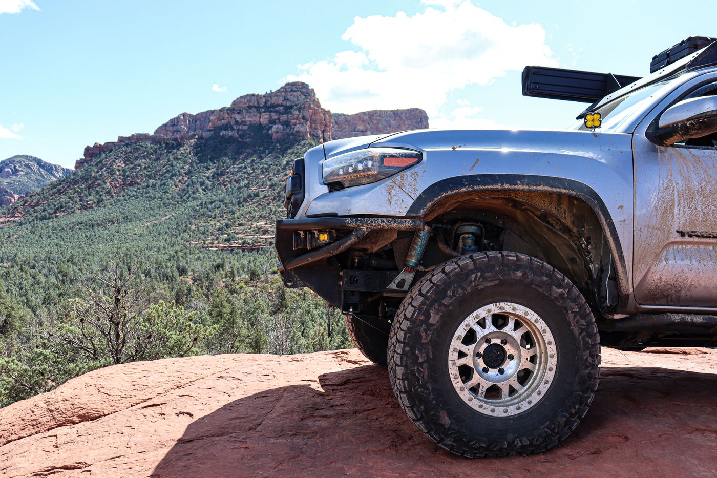Close-up of wheel, shock, and fender against a canyon backdrop