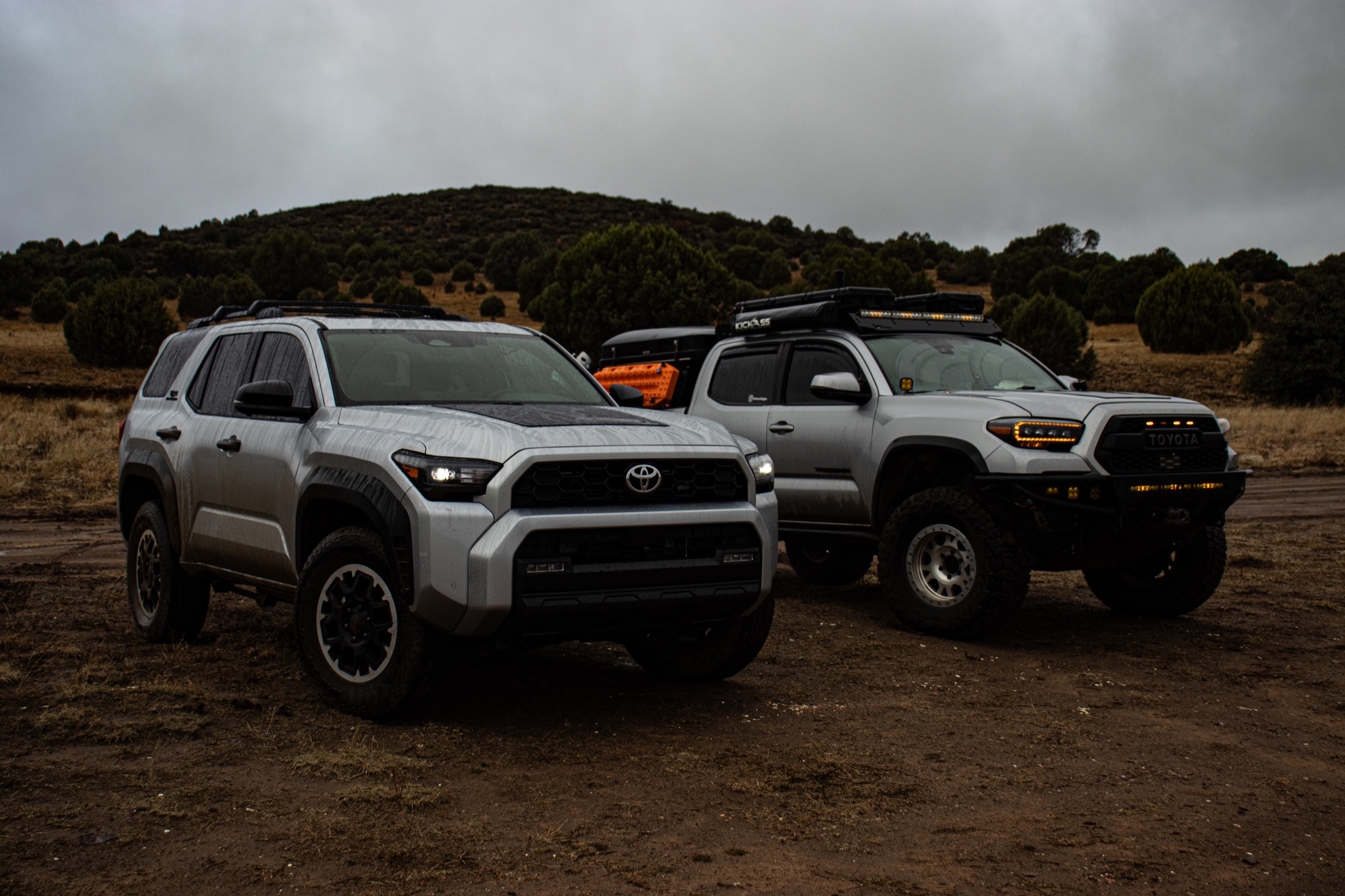 Two trucks in rugged outdoor terrain